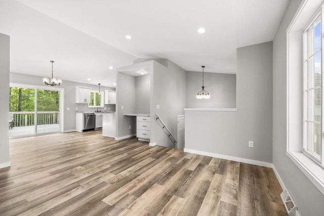6611 Conner Davis Dr, Wausau, WI 54401 - unfurnished living room featuring a chandelier, wood finished floors, recessed lighting, and lofted ceiling