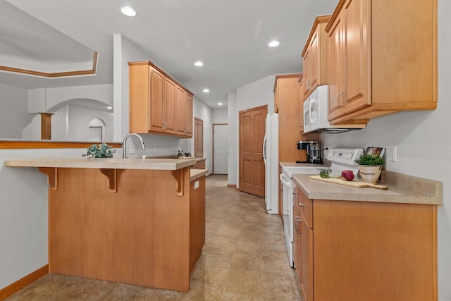 2506 Waterford Ct, Neenah, WI 54956 - kitchen featuring white appliances, a kitchen breakfast bar, a peninsula, recessed lighting, and light countertops