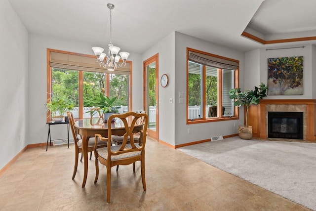 2506 Waterford Ct, Neenah, WI 54956 - dining area featuring a chandelier, plenty of natural light, and a fireplace with flush hearth