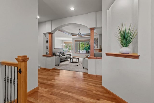 2506 Waterford Ct, Neenah, WI 54956 - hallway featuring ornate columns, arched walkways, wood finished floors, recessed lighting, and a raised ceiling