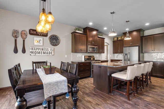2210 Stoney Brook Dr, Manitowoc, WI 54220 - kitchen with stainless steel appliances, dark brown cabinetry, dark wood-style floors, backsplash, and recessed lighting