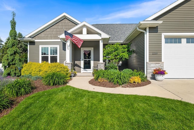 2210 Stoney Brook Dr, Manitowoc, WI 54220 - craftsman-style home with stone siding, a front yard, a garage, and driveway