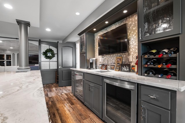 2210 Stoney Brook Dr, Manitowoc, WI 54220 - indoor wet bar featuring wine cooler, ornate columns, recessed lighting, and dark wood finished floors