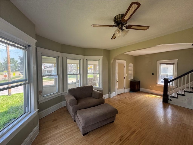 397 W Main St, Mondovi, WI 54755 - sitting room with arched walkways, light wood-type flooring, stairs, a ceiling fan, and a textured ceiling