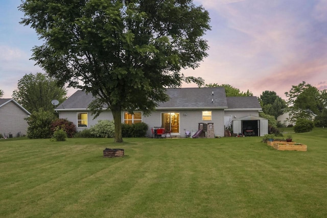 W5355 Linden Hill Dr, Appleton, WI 54915 - back of house at dusk featuring an outdoor structure, a yard, and a fire pit