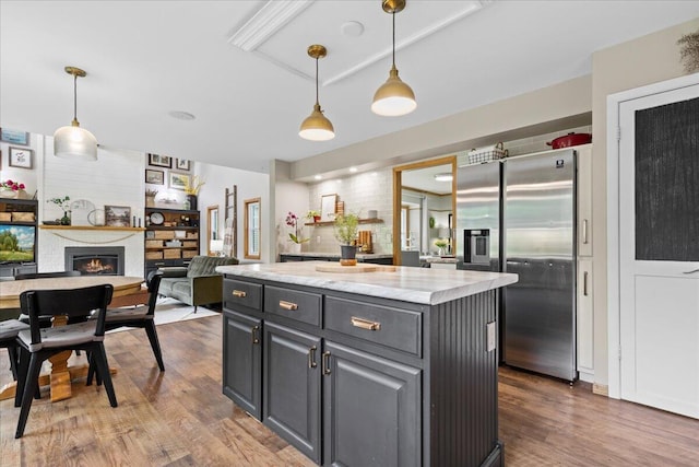 1021 Aspen Pl, West Bend, WI 53095 - kitchen featuring stainless steel fridge, a center island, light countertops, and hanging light fixtures
