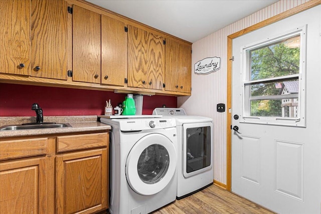 1021 Aspen Pl, West Bend, WI 53095 - washroom with cabinet space, washer and clothes dryer, light wood-style floors, and wallpapered walls