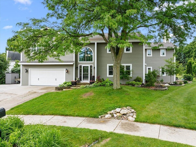 1021 Aspen Pl, West Bend, WI 53095 - traditional home with concrete driveway, an attached garage, and a front yard