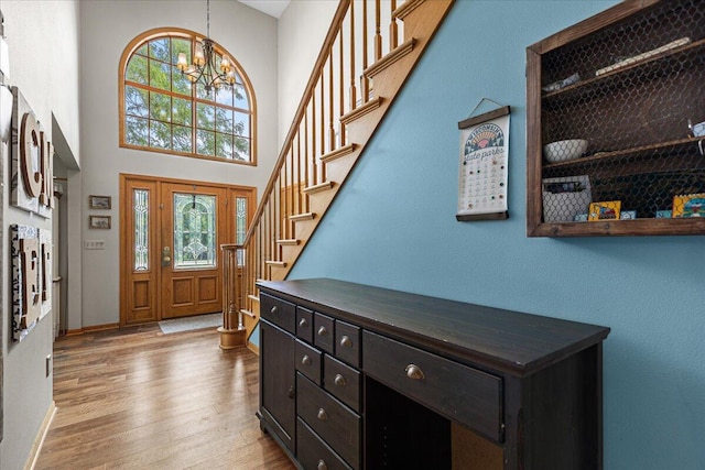 1021 Aspen Pl, West Bend, WI 53095 - foyer entrance featuring plenty of natural light, stairs, wood finished floors, a towering ceiling, and a chandelier