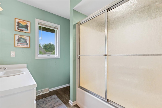 1021 Aspen Pl, West Bend, WI 53095 - bathroom with wood finished floors, vanity, and combined bath / shower with glass door