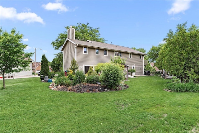 1021 Aspen Pl, West Bend, WI 53095 - rear view of house featuring a chimney and a yard