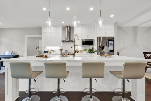 742 Charolais Dr, Slinger, WI 53086 - kitchen featuring appliances with stainless steel finishes, wall chimney range hood, a large island with sink, white cabinetry, and light countertops