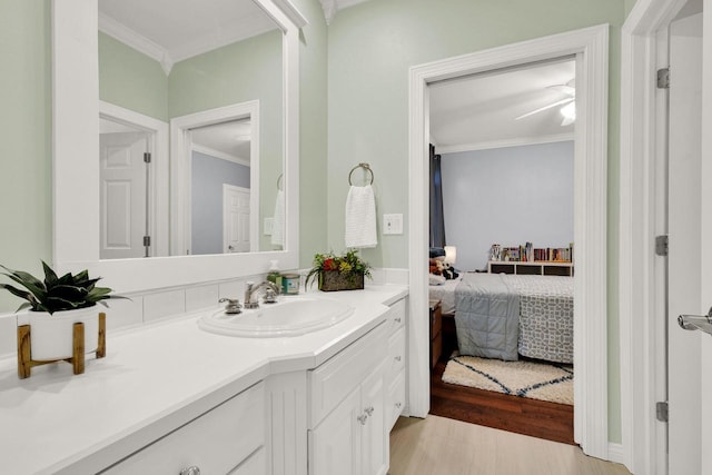 742 Charolais Dr, Slinger, WI 53086 - bathroom with vanity, ornamental molding, connected bathroom, and wood finished floors