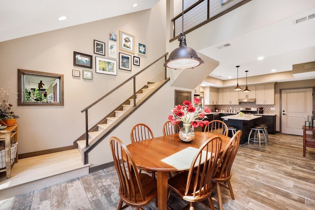 2830 Tomahawk Ct, Middleton, WI 53562 - dining area featuring light wood-type flooring, recessed lighting, stairs, and high vaulted ceiling
