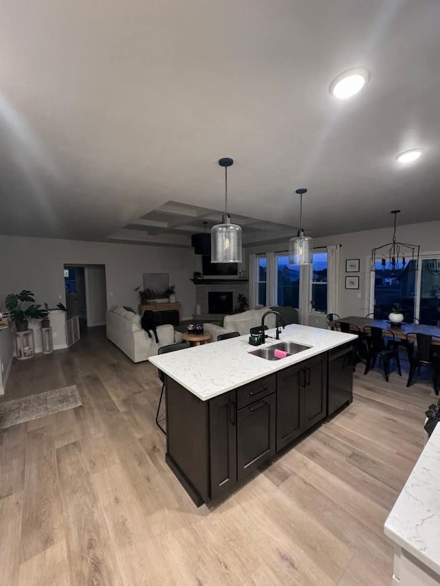 117 Cortland Ave, Casco, WI 54205 - kitchen with light wood-type flooring, hanging light fixtures, an island with sink, open floor plan, and light stone countertops
