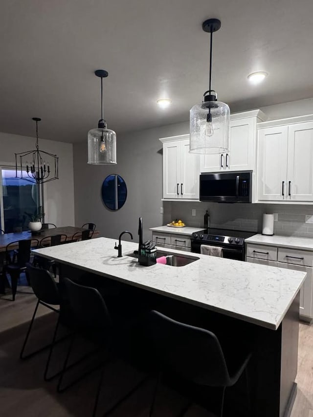 117 Cortland Ave, Casco, WI 54205 - kitchen with black microwave, electric stove, a breakfast bar area, decorative backsplash, and light wood-type flooring