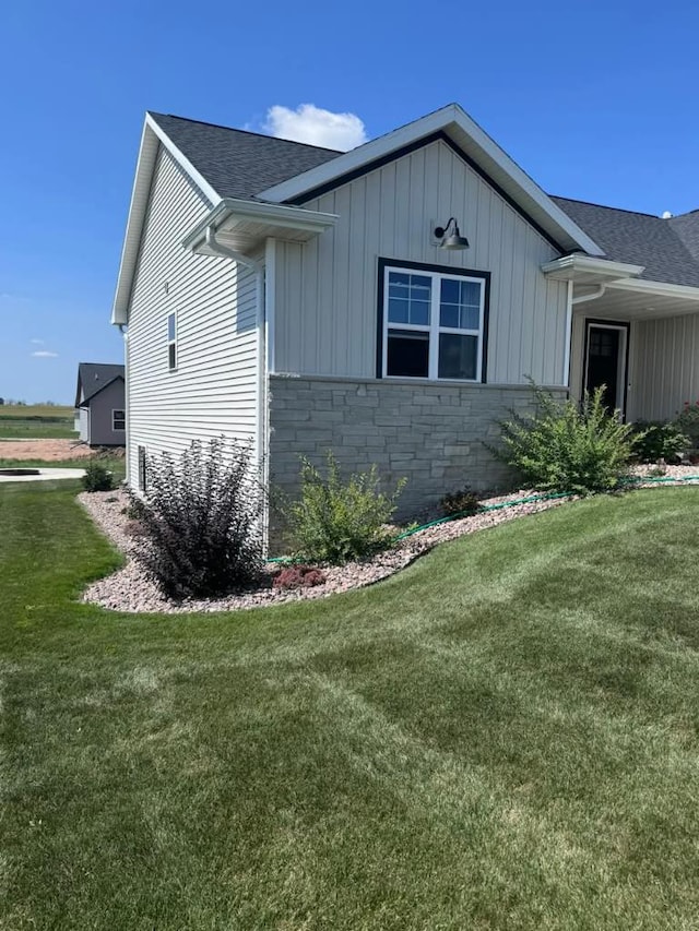 117 Cortland Ave, Casco, WI 54205 - view of side of home with roof with shingles, stone siding, a lawn, and board and batten siding