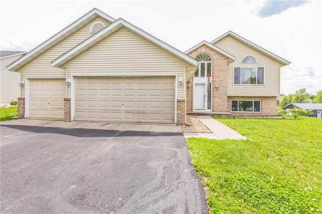 1566 Mallard Ave, Baldwin, WI 54002 - view of front of home with brick siding, driveway, an attached garage, and a front lawn