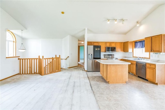 1566 Mallard Ave, Baldwin, WI 54002 - kitchen featuring appliances with stainless steel finishes, a center island, vaulted ceiling, light countertops, and rail lighting