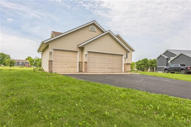 1566 Mallard Ave, Baldwin, WI 54002 - view of front facade featuring driveway, a front lawn, brick siding, and a garage