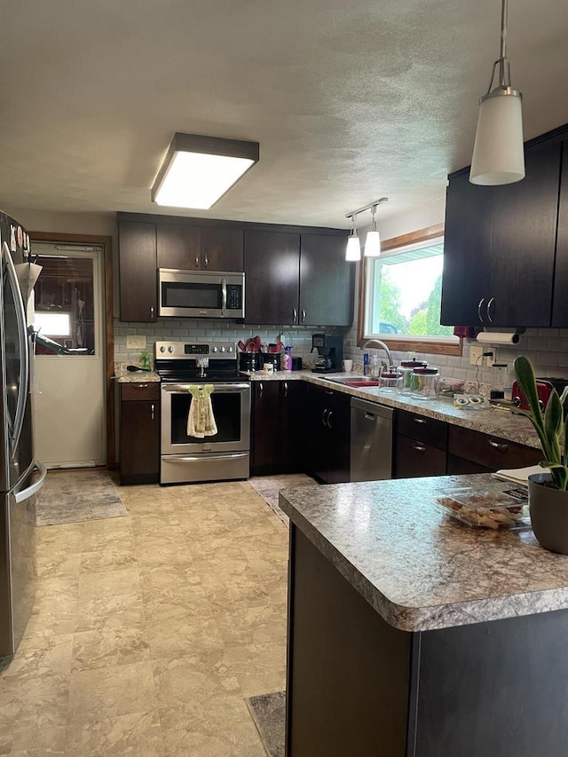 1508 Hoover St, New Holstein, WI 53061 - kitchen with appliances with stainless steel finishes, backsplash, and pendant lighting