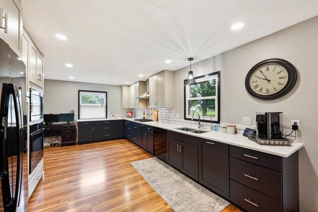 W365N7134 Mcmahon Rd, Oconomowoc, WI 53066 - kitchen featuring black appliances, light wood-style flooring, light countertops, tasteful backsplash, and recessed lighting