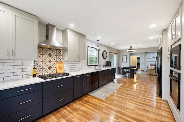 W365N7134 Mcmahon Rd, Oconomowoc, WI 53066 - kitchen featuring wall chimney range hood, black appliances, light countertops, light wood-style floors, and recessed lighting