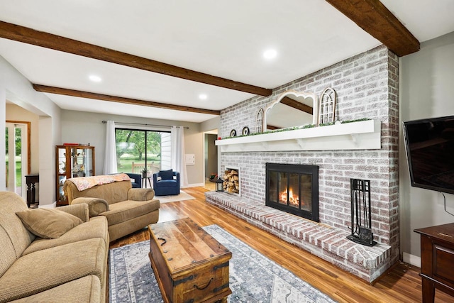 W365N7134 Mcmahon Rd, Oconomowoc, WI 53066 - living room featuring a brick fireplace, wood finished floors, beam ceiling, and recessed lighting