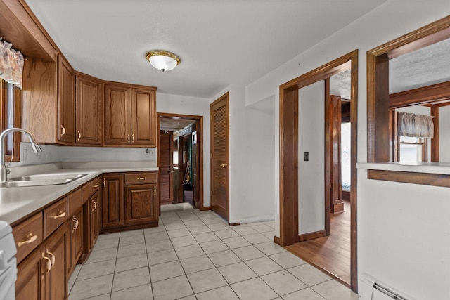 2963 Sunset Point Ln, Oshkosh, WI 54904 - kitchen with light countertops, light tile patterned floors, baseboard heating, stove, and brown cabinets