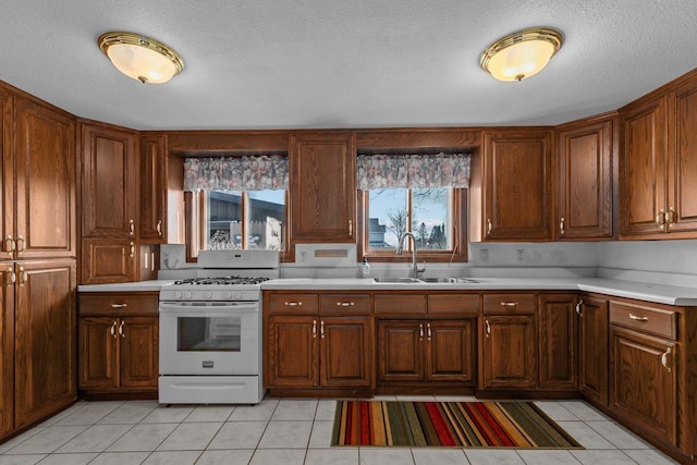 2963 Sunset Point Ln, Oshkosh, WI 54904 - kitchen featuring white gas stove, light countertops, light tile patterned floors, and brown cabinets