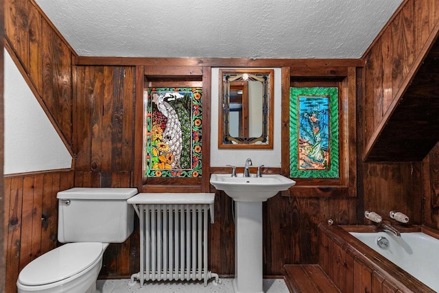 2963 Sunset Point Ln, Oshkosh, WI 54904 - bathroom featuring radiator, wooden walls, a textured ceiling, and a bath