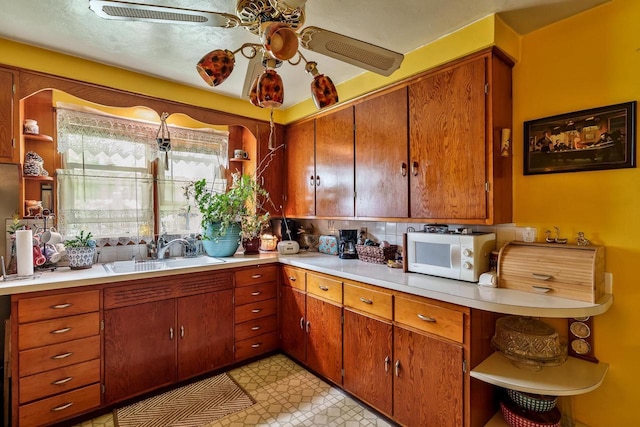 1422 S Burchard Ave, Freeport, IL 61032 - kitchen with white microwave, open shelves, ceiling fan, light countertops, and brown cabinets