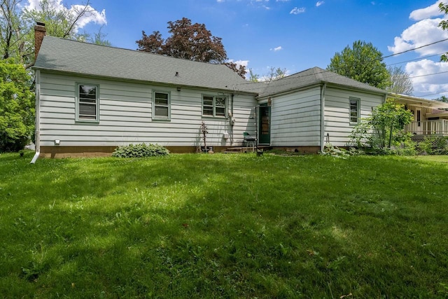 1422 S Burchard Ave, Freeport, IL 61032 - back of house with a chimney, a lawn, and a shingled roof