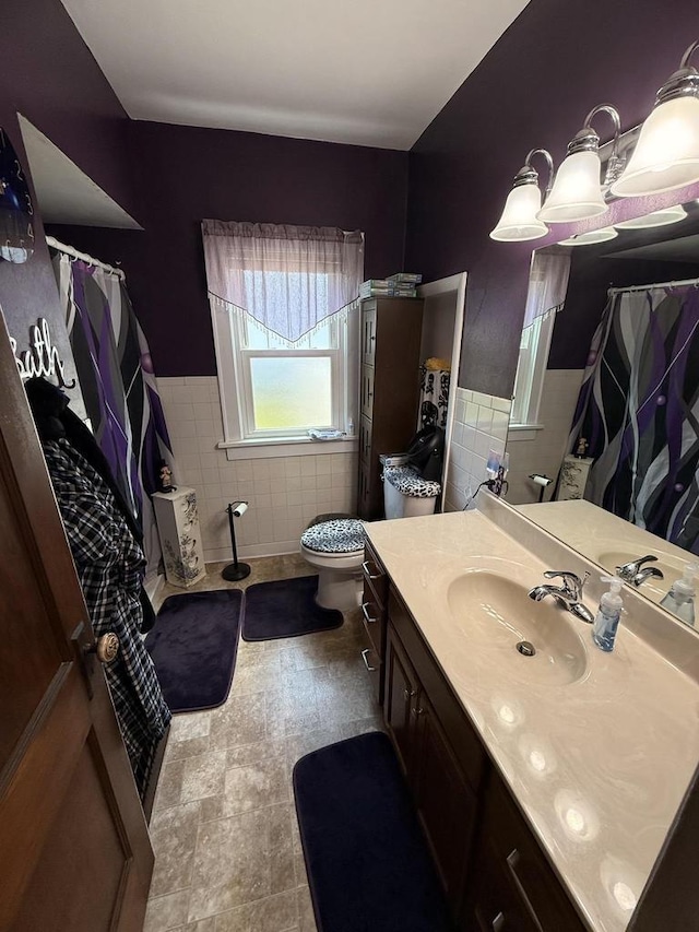 810 10th St, Monroe, WI 53566 - bathroom with tile walls, vanity, a shower with curtain, and wainscoting