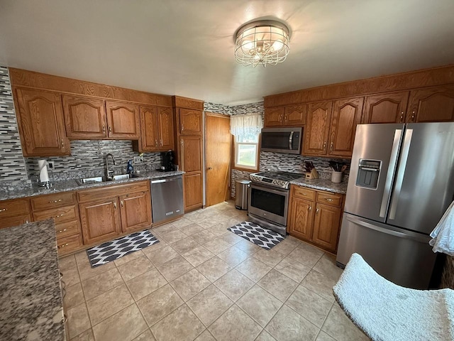 810 10th St, Monroe, WI 53566 - kitchen with stainless steel appliances, brown cabinets, decorative backsplash, and stone counters