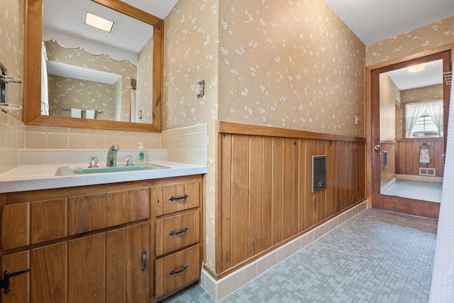 7873 N Edgeworth Dr, Milwaukee, WI 53223 - bathroom with wallpapered walls, a wainscoted wall, vanity, and backsplash