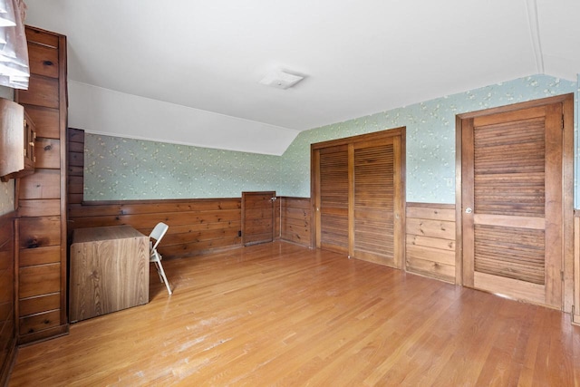 7873 N Edgeworth Dr, Milwaukee, WI 53223 - additional living space featuring lofted ceiling, wallpapered walls, wood finished floors, and a wainscoted wall