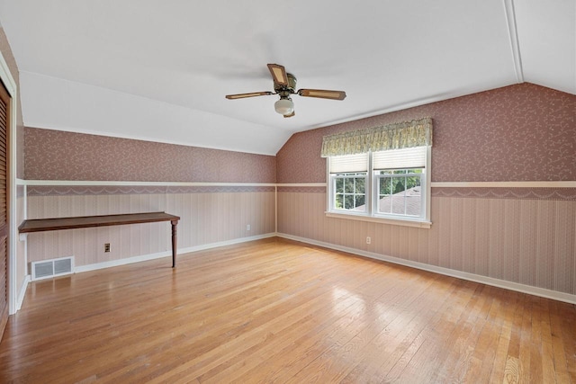 7873 N Edgeworth Dr, Milwaukee, WI 53223 - unfurnished room with hardwood / wood-style flooring, lofted ceiling, ceiling fan, wallpapered walls, and wainscoting