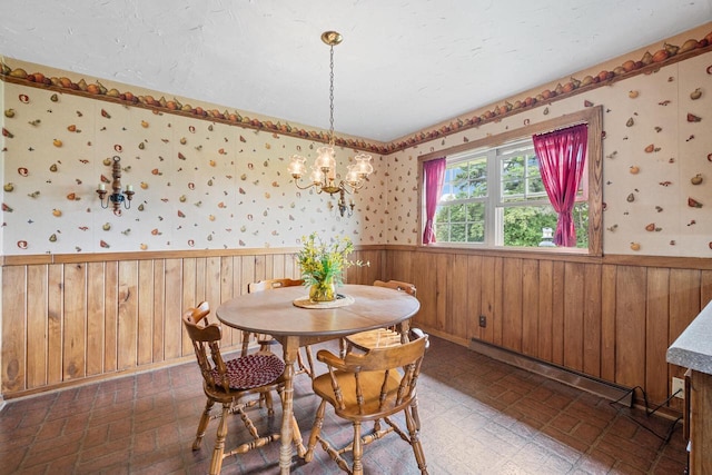 7873 N Edgeworth Dr, Milwaukee, WI 53223 - dining room featuring a baseboard radiator, a wainscoted wall, a chandelier, wallpapered walls, and wood walls