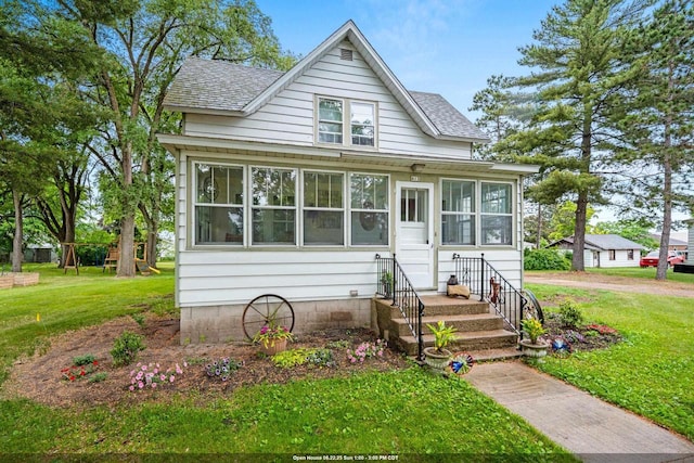 413 S Howard St, Princeton, WI 54968 - bungalow-style house featuring a shingled roof, a front lawn, and a sunroom