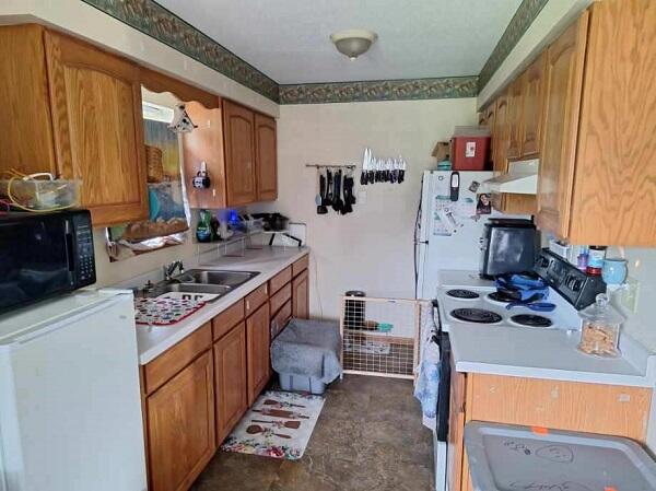 113/115 Oak St, Stoddard, WI 54658 - kitchen featuring black microwave, white range with electric cooktop, exhaust hood, refrigerator, and light countertops