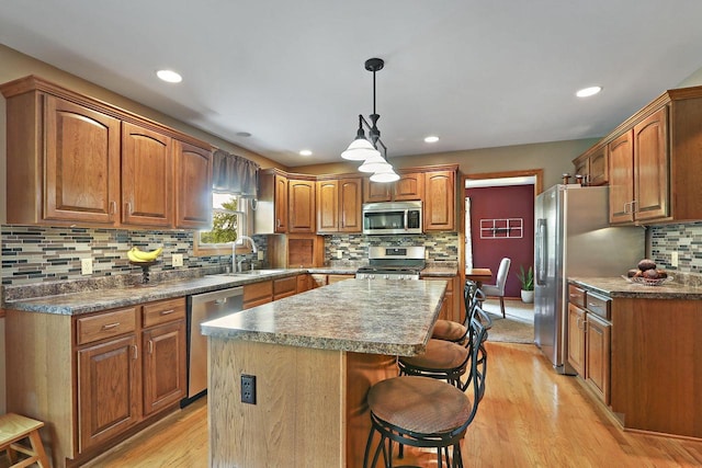 32665 Academy Rd, Burlington, WI 53105 - kitchen featuring stainless steel appliances, tasteful backsplash, light wood-type flooring, a center island, and a breakfast bar area