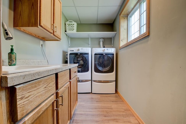 1410 Edwin St, Marinette, WI 54143 - laundry area featuring washing machine and dryer, light wood-style floors, and cabinet space