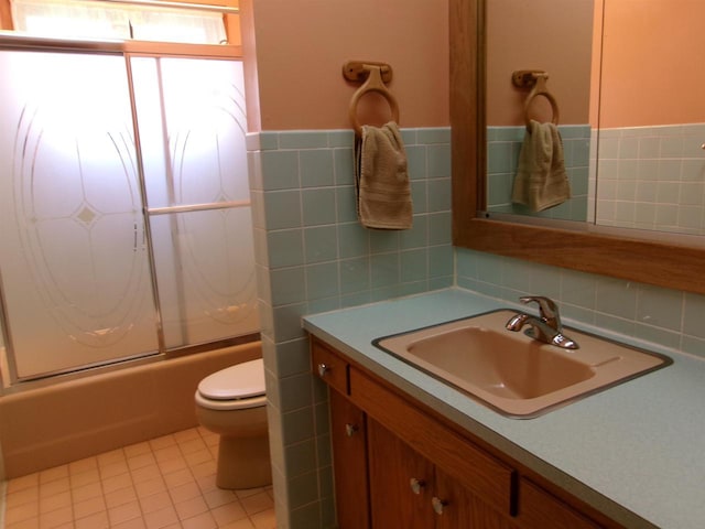 116 Mohawk Dr, Beaver Dam, WI 53916 - full bathroom with vanity, combined bath / shower with glass door, tile patterned flooring, and tile walls