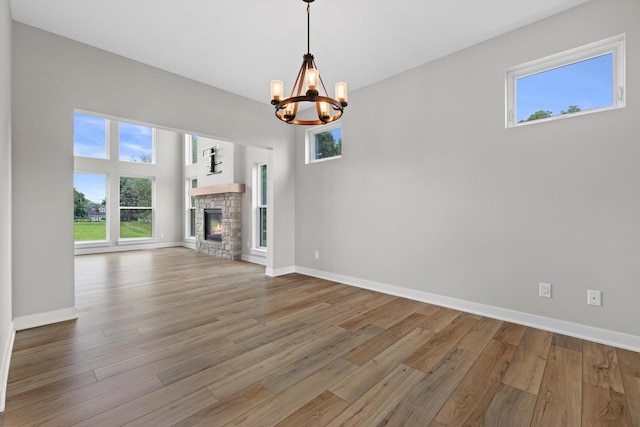 N65W34963 Baltic Pass, Oconomowoc, WI 53066 - unfurnished living room featuring a chandelier, plenty of natural light, and wood finished floors