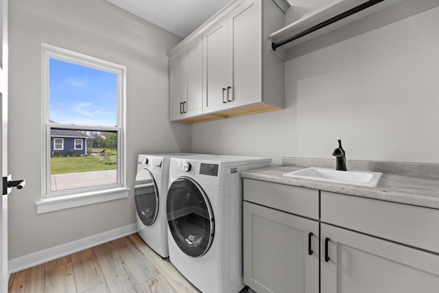 N65W34963 Baltic Pass, Oconomowoc, WI 53066 - laundry area with cabinet space, washing machine and dryer, and light wood-style flooring