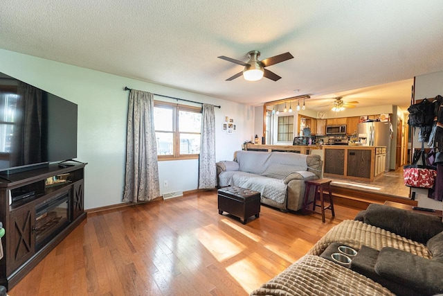1116 Lagrange Ave, Tomah, WI 54660 - living area featuring a ceiling fan, light wood-style flooring, and a textured ceiling