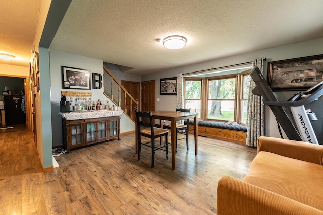 1116 Lagrange Ave, Tomah, WI 54660 - dining room featuring stairway, a textured ceiling, wood finished floors, and bar area
