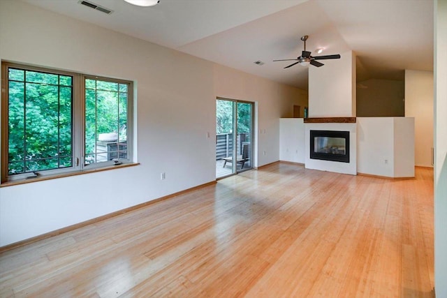1140 E Dayton St Unit 205, Madison, WI 53703 - unfurnished living room featuring light wood-type flooring, lofted ceiling, a multi sided fireplace, and a ceiling fan