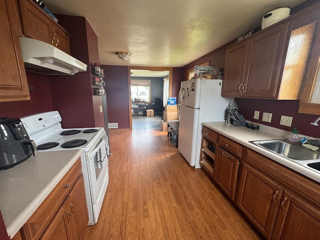 2101 Redfield St, La Crosse, WI 54601 - kitchen with white appliances, under cabinet range hood, light wood finished floors, and light countertops